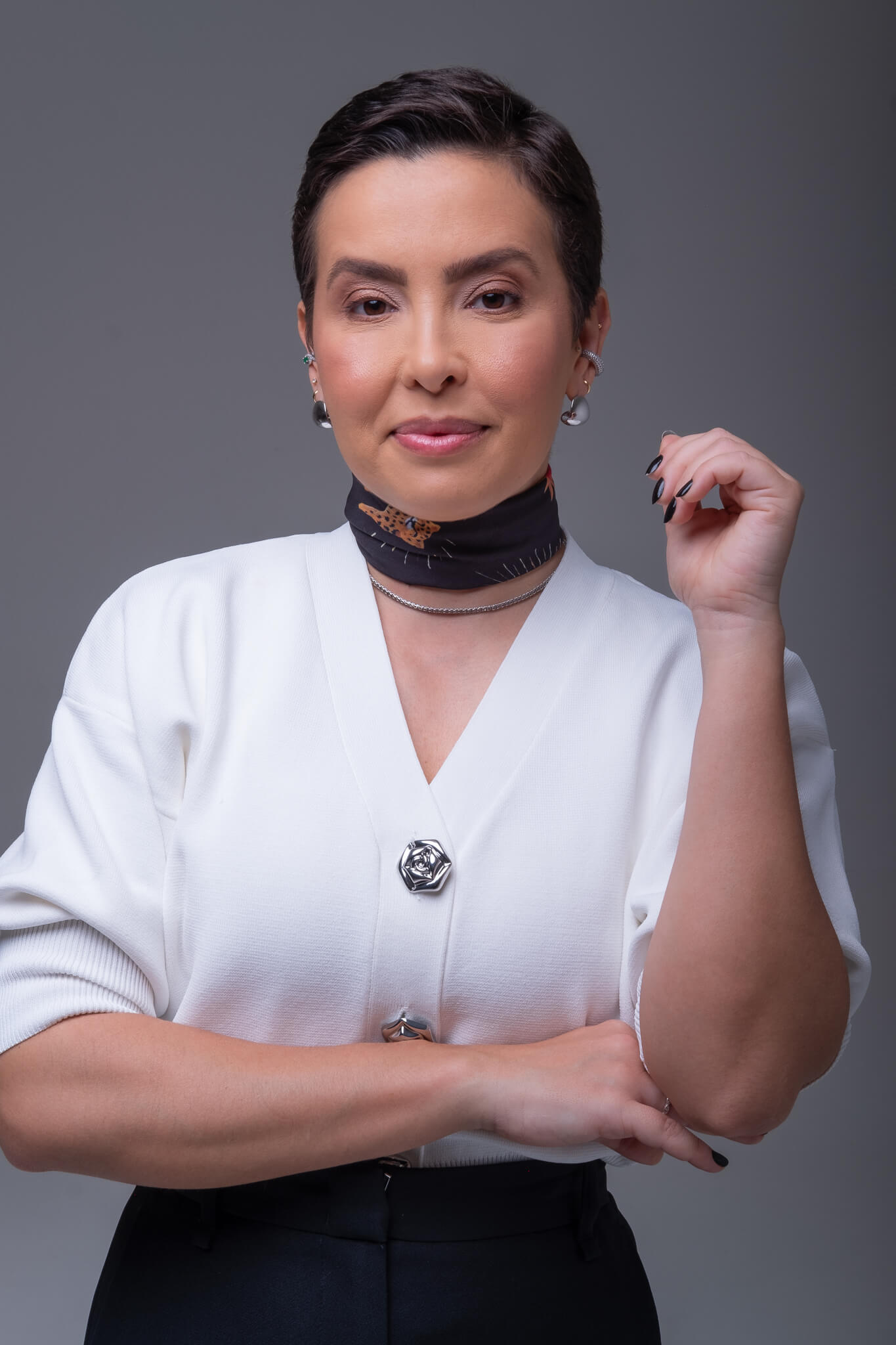 Uma mulher confiante e elegantemente vestida em um look minimalista, com um sorriso genuíno, em um ambiente clean e iluminado.